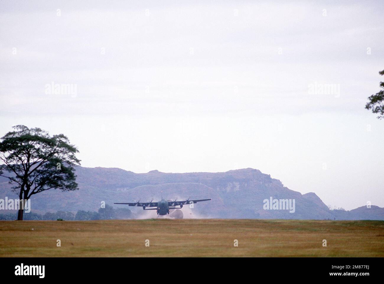 A C130 Hercules aircraft releases a drogue chute as members of the