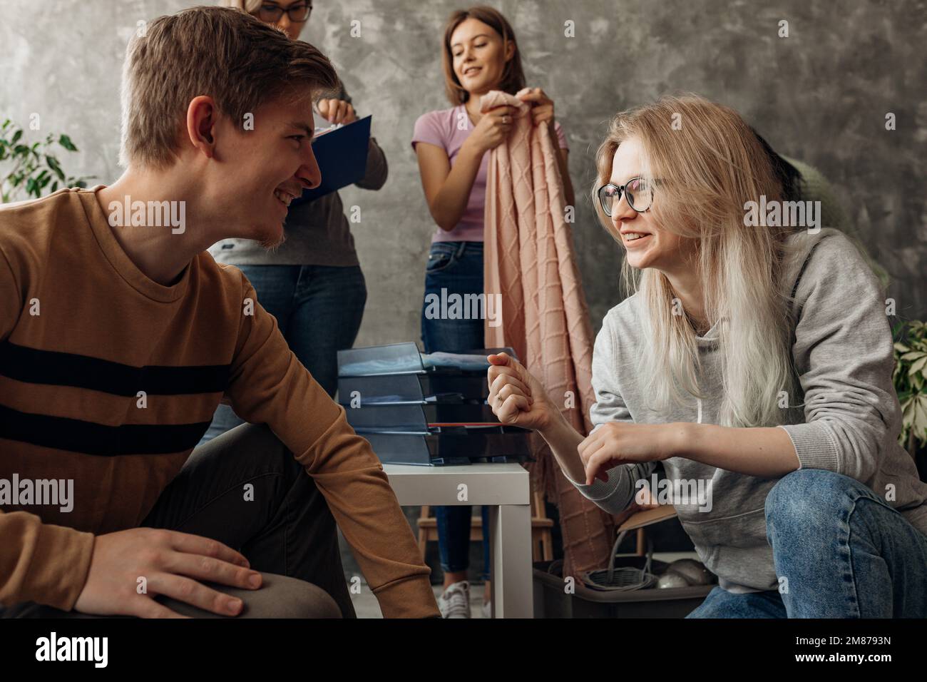 Smiling, talking playful woman and man packing and collect clothes and linen stuff in dorm after neighbor flooding. Safe Stock Photo