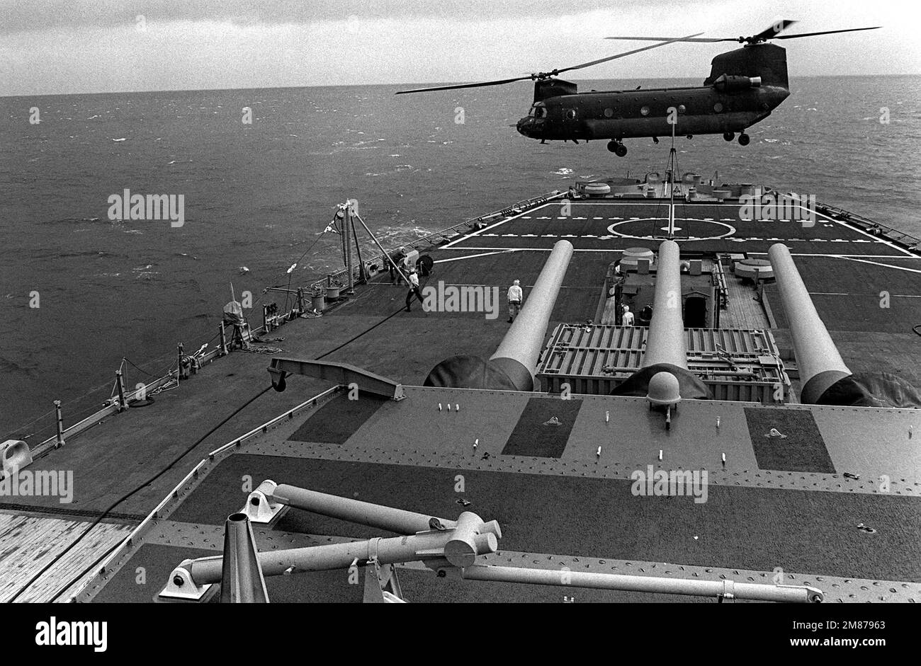 A U.S. Army CH-47 Chinook helicopter takes off from the deck of the battleship USS IOWA (BB-61). The helicopter is being used for personnel transport and re-supply while the ship is in port to participate in a civic action program. Base: Puerto Cortes Country: Honduras (HND) Stock Photo