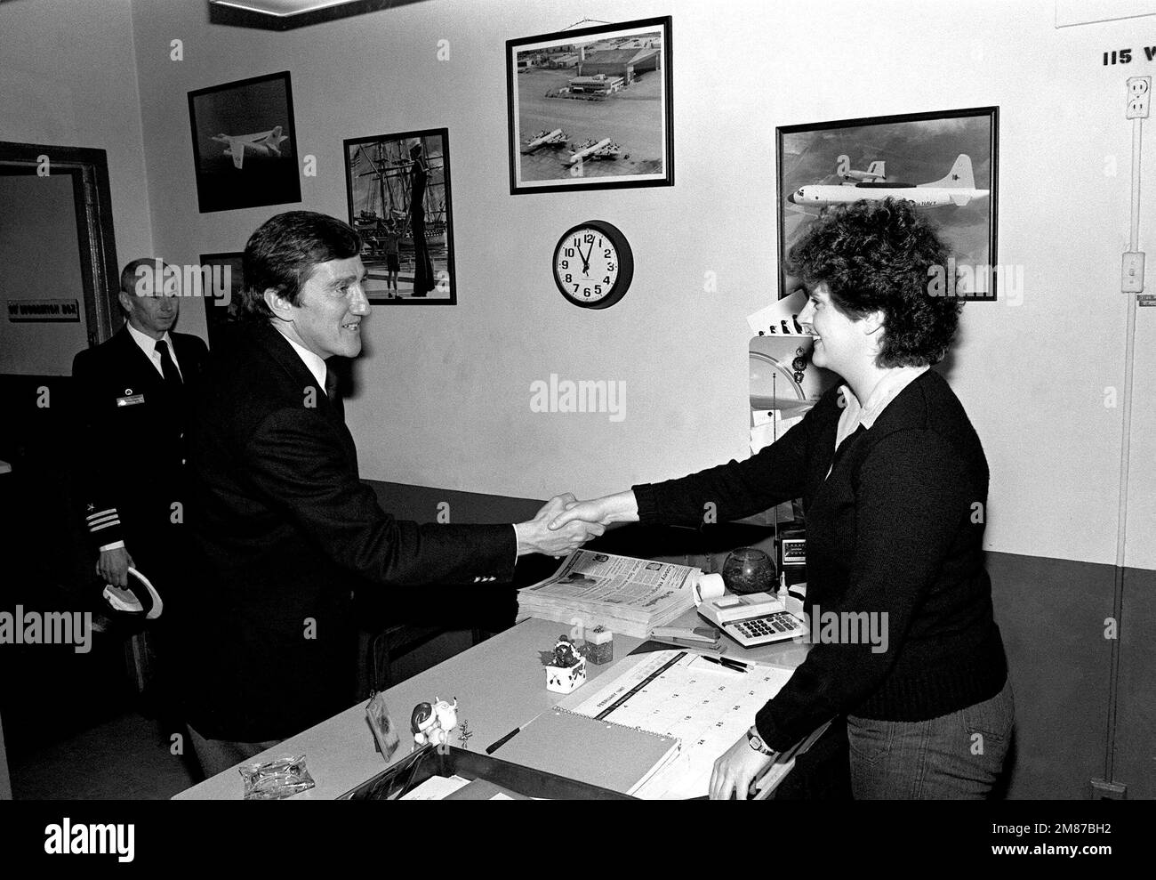 Secretary of the Navy John F. Lehman Jr. shakes hands with AIRMAN ...