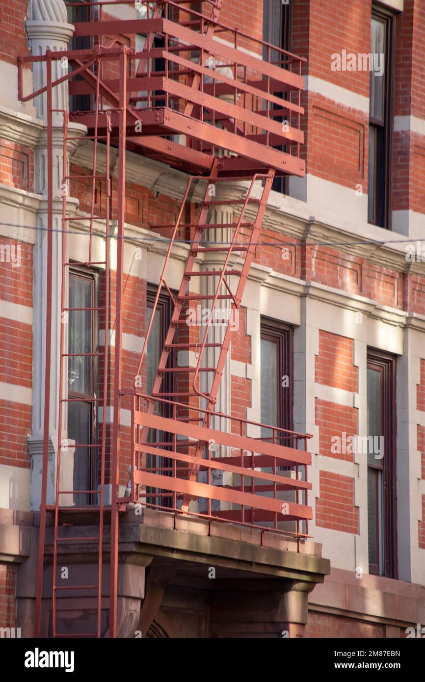 A vertical shot of a fire escape staircase of a red brick building in ...
