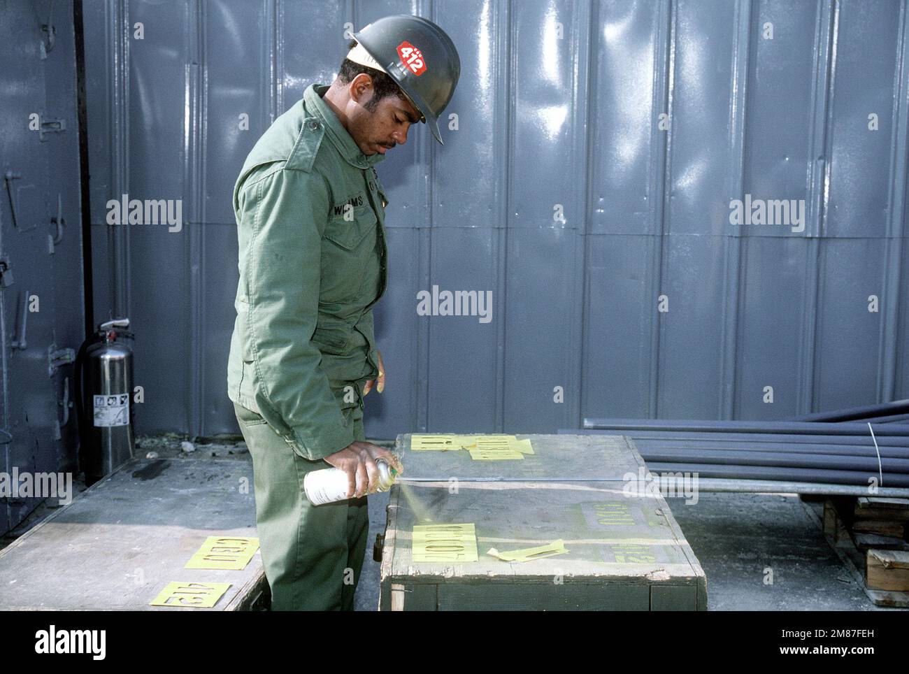 A Construction Battalion Unit 412 (CBU-412) steelworker labels storage