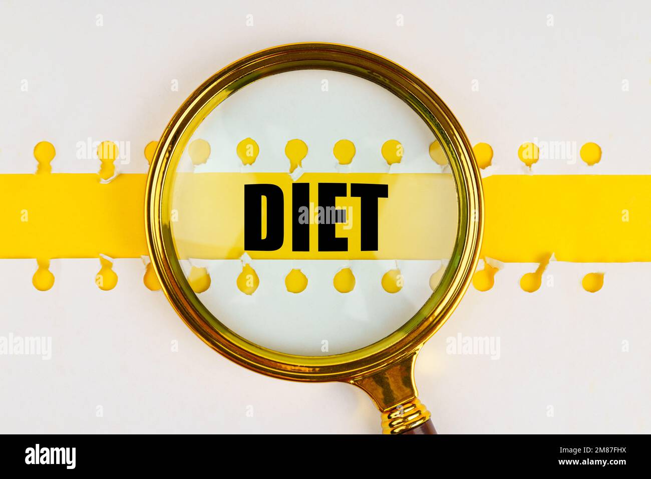 Between two sheets from a notebook on a yellow strip with the inscription - Diet, there is a magnifying glass. Stock Photo