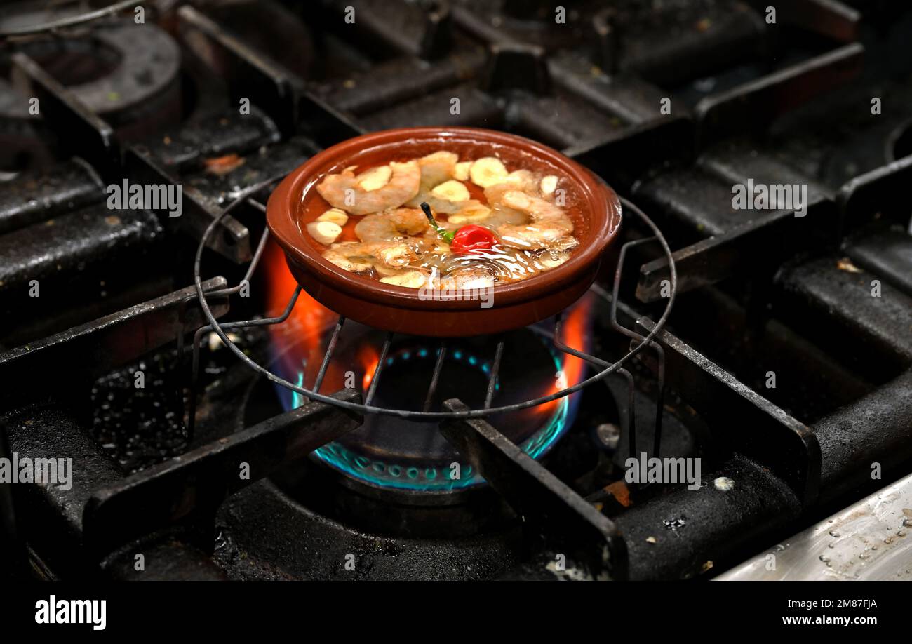 Prawns sizzling in garlic oil while cooking Stock Photo