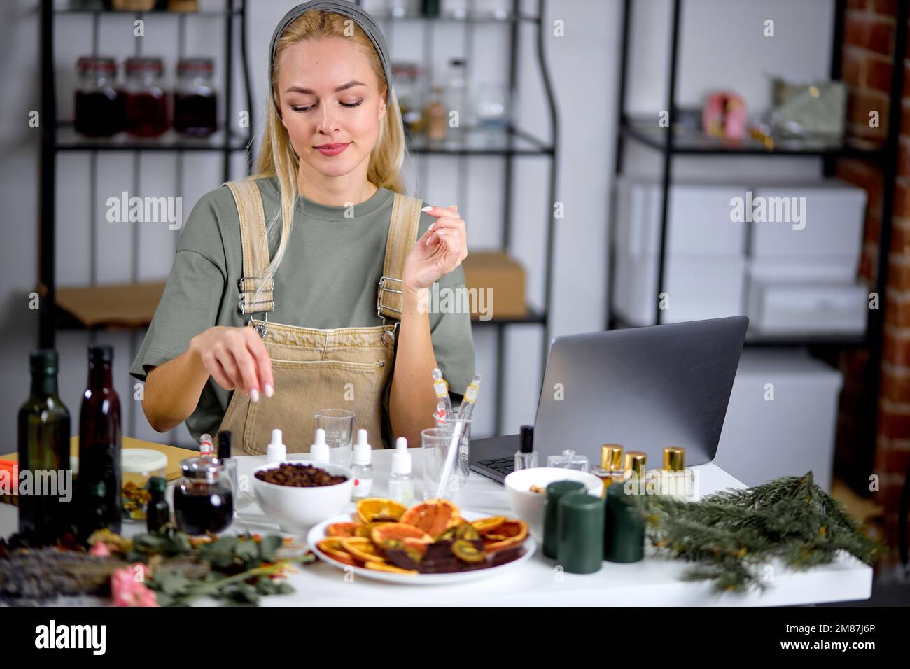 fragrance bottles used for blending scent for making perfume by professional female perfumer in cozy modern laboratory. attractive caucasian female in Stock Photo