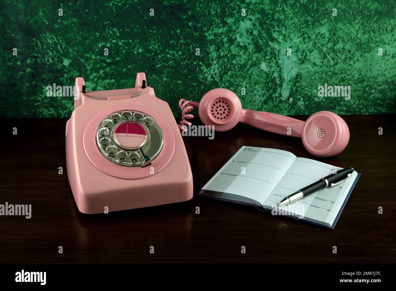 Old pink telephone with pen and diary on a varnished wooden shelf Stock ...