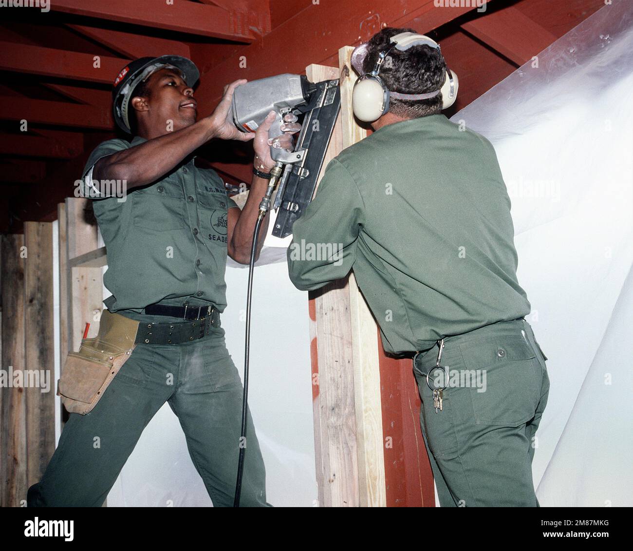 A Construction Battalion Unit 412 (CBU-412) builder uses a pneumatic