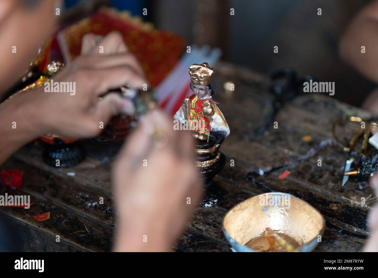 A street vendor re-decorates a Santo Nino figurine during the annual Sinulog Festival, Cebu City, Philippines Stock Photo