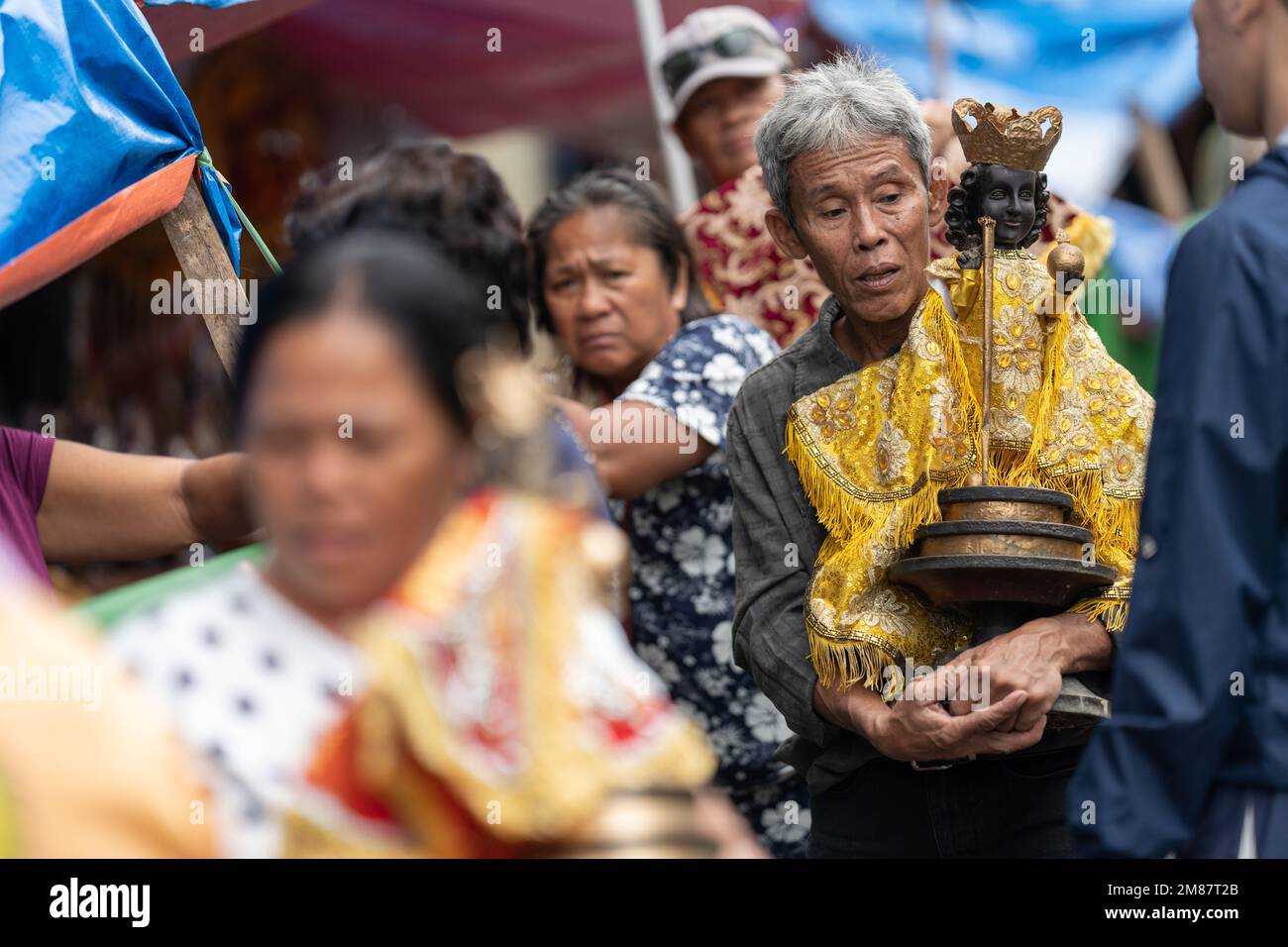 A man carrying a large Santo Nino Figurine during the annual Sinulog Festival, Cebu City, Philippines Stock Photo