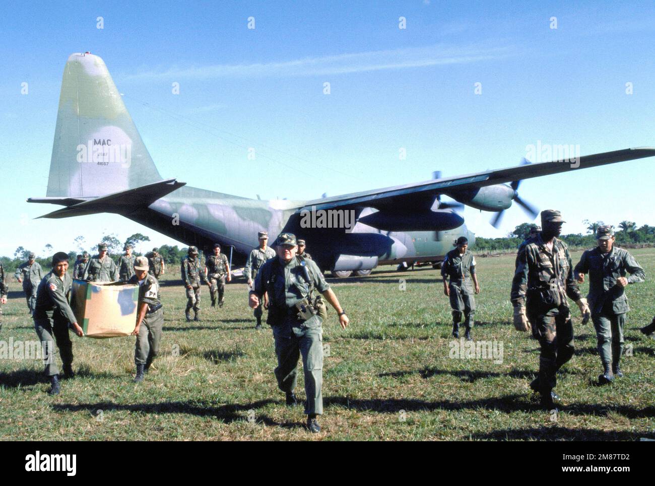 U.S. and Bolivian personnel unload a C130 Hercules from the 463rd Military Airlift Wing during