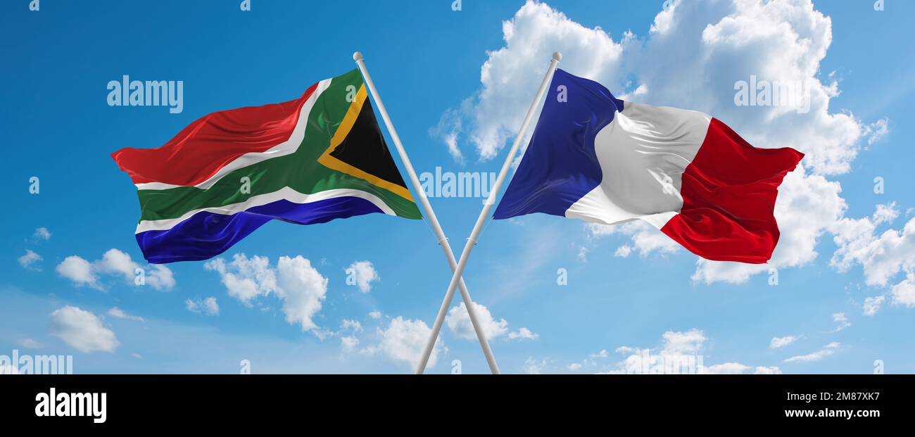 two crossed flags France and South Africa waving in wind at cloudy sky ...
