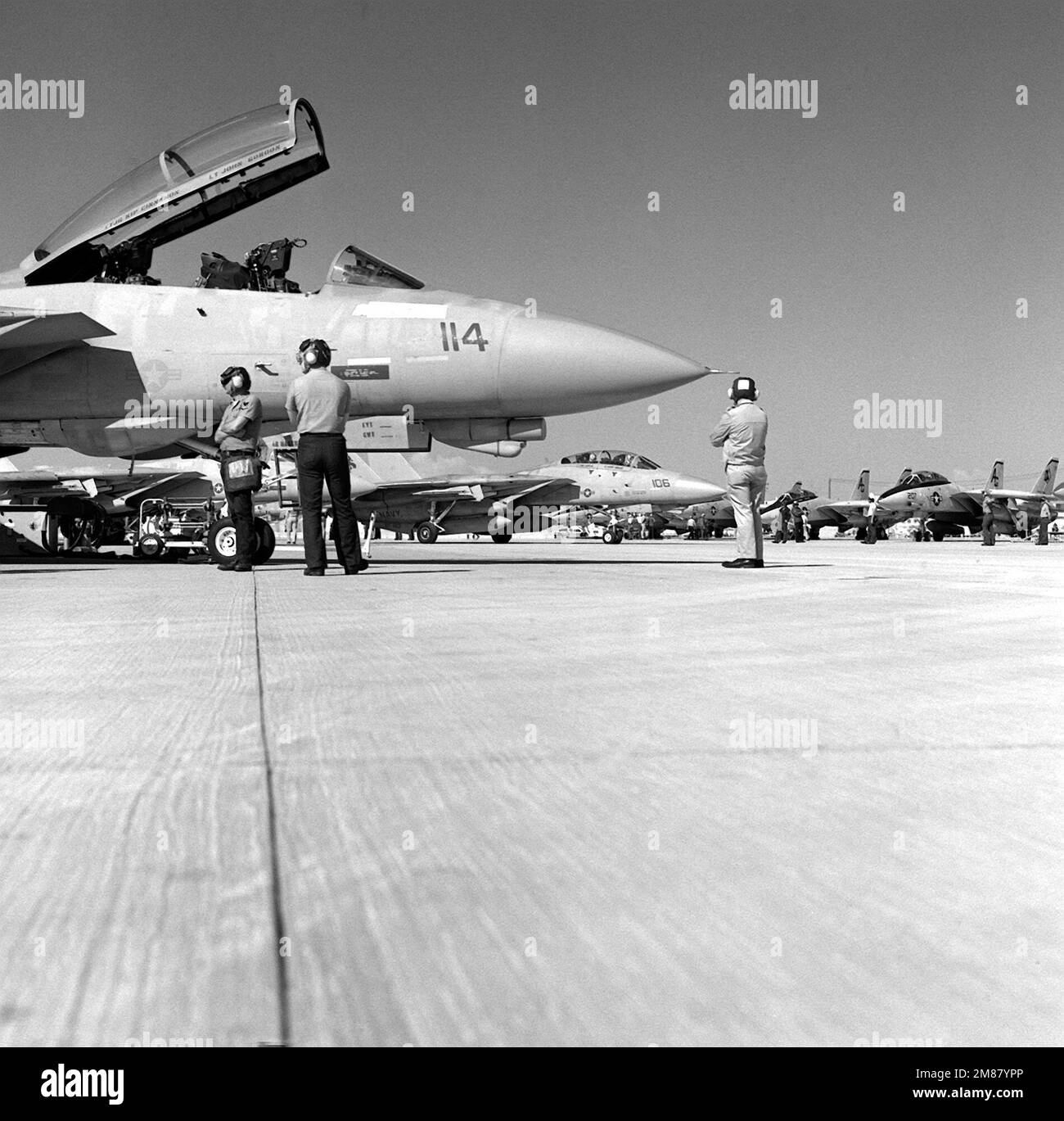 Line crewmen ready an F-14A Tomcat aircraft for takeoff while another Tomcat from Fighter Squadron 143 (VF-143) taxies for takeoff during Carrier Air Wing 7 (CVW-7) strike training. Base: Naval Air Station, Fallon State: Nevada (NV) Country: United States Of America (USA) Stock Photo