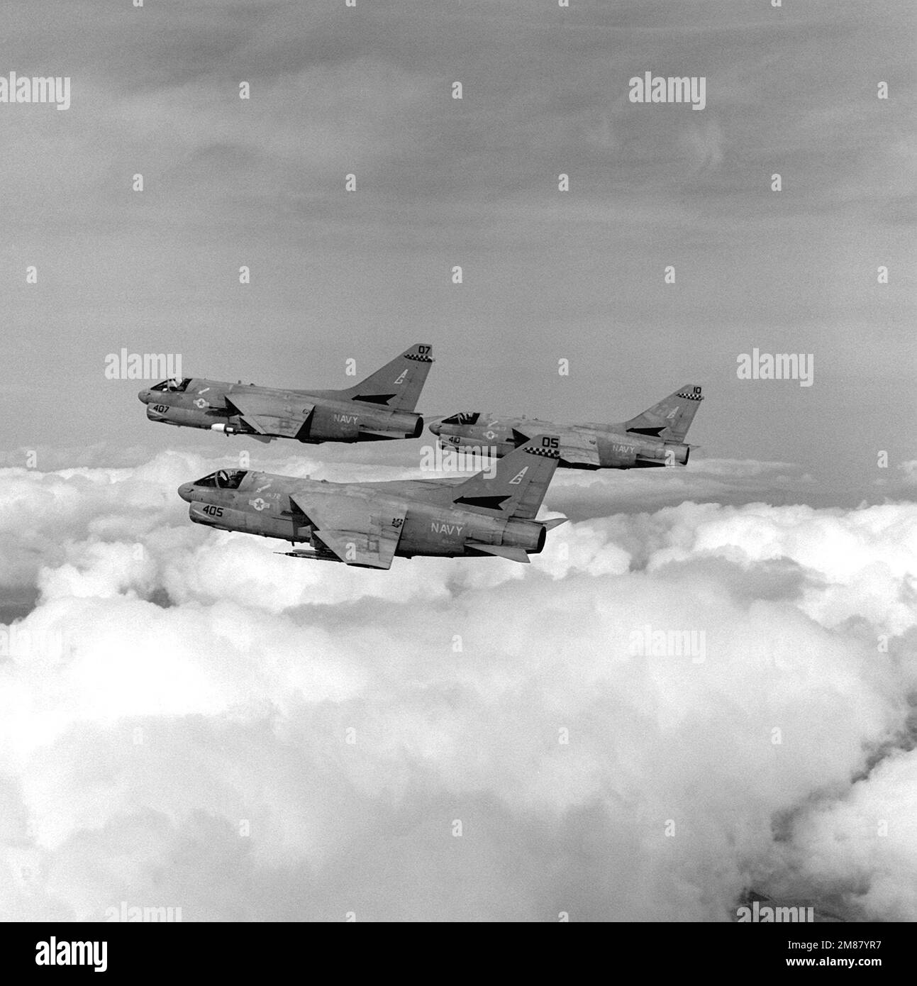 An air-to-air left side view of three Attack Squadron 72 (VA-72) A-7E