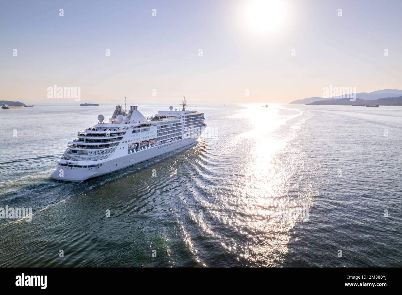 Cruise ship sailing out of Vancouver harbour at sunset, cruise line, large boat, luxury cruise, aerial footage. Stock Photo