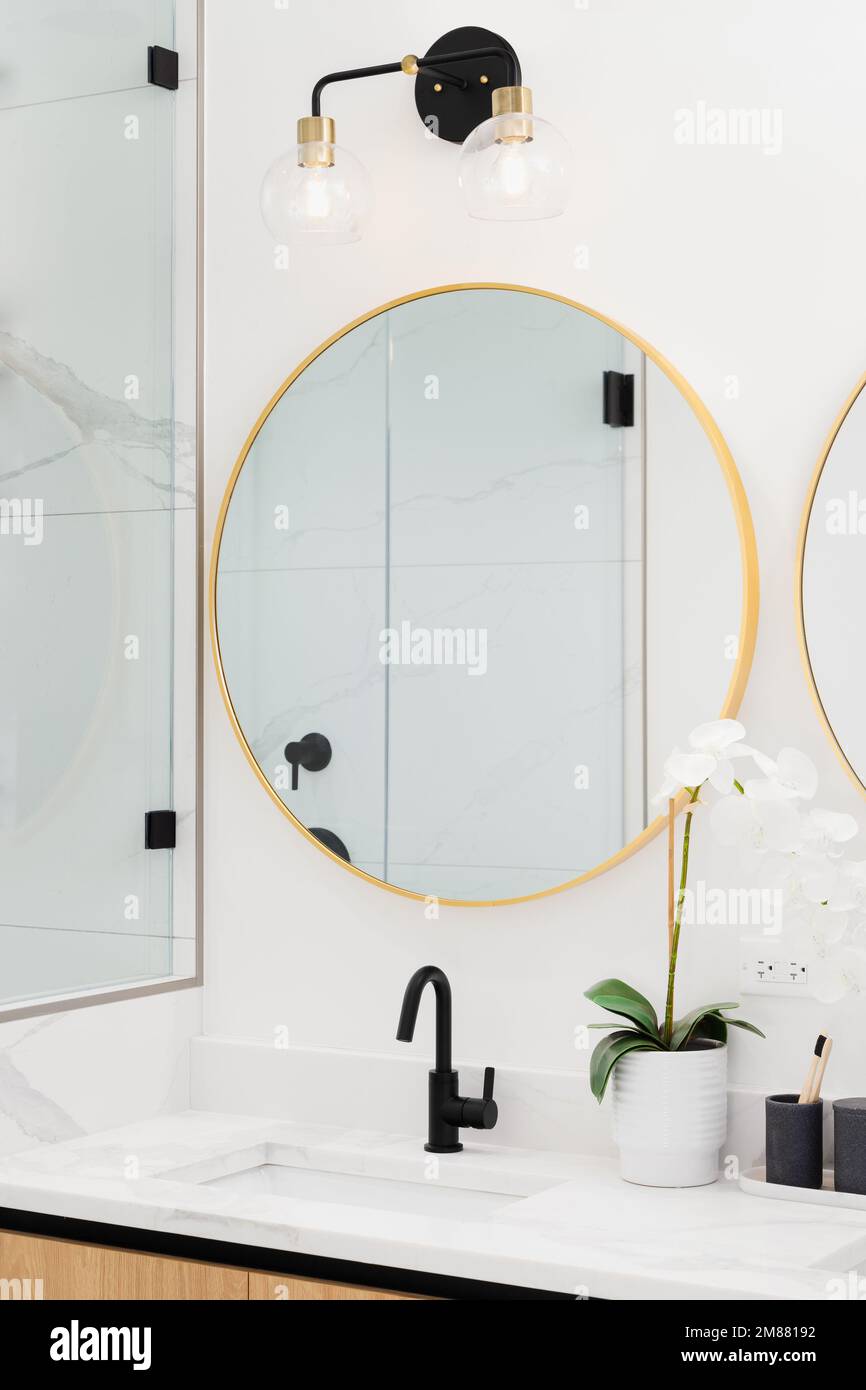 A beautiful bathroom with a wood marble countertop, and gold