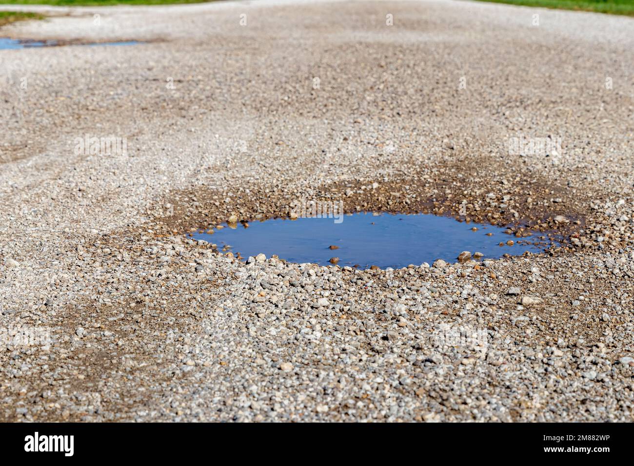 Pothole, chuckhole, in gravel road. Rock road repair, maintenance and damage concept Stock Photo