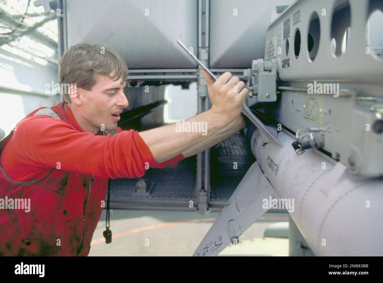 Ordnancemen check the position of an RIM-7 Sea Sparrow missile being ...