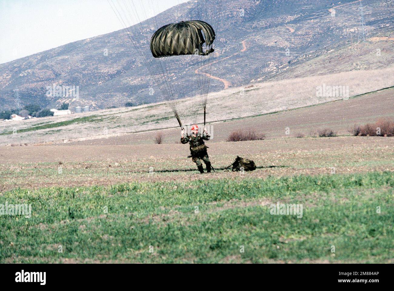 A trainee parachutes to the ground during Basic Underwater Demolition/SEAL (BUD/S) training. Country: Unknown Stock Photo