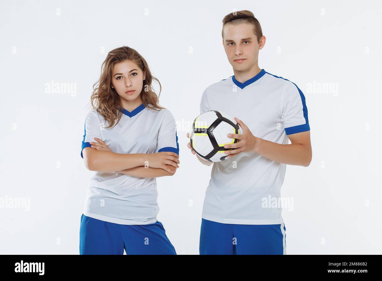 Soccer player and a girl footballer in a white uniform with a ball isolated Stock Photo