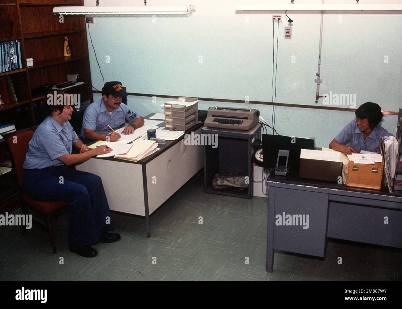 Mineman 2nd Class Marian Noonan, Mineman 1ST Class Vincent Price and Mineman 3rd Class Nina Jacobson, all members of the Mobile Mine Assembly Group Unit 5 quality assurance team, complete administrative work in their office. Base: Naval Air Station, Sigonella State: Sicily Country: Italy (ITA) Stock Photo