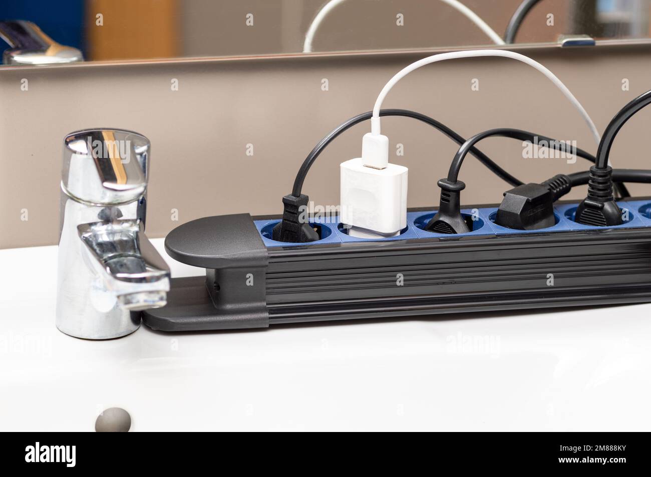 Close up of a plug in an electrical socket at bathroom with many