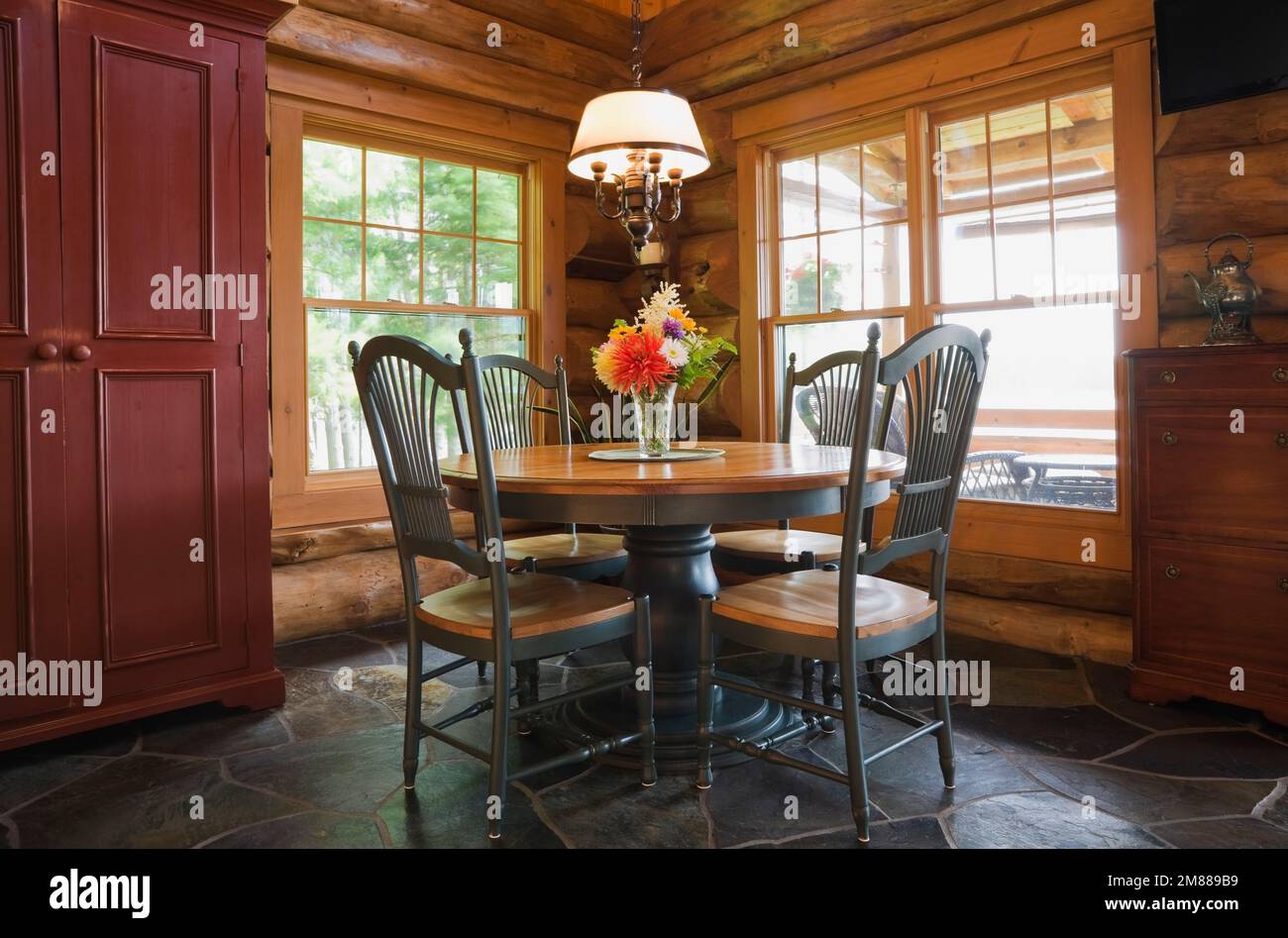 Round wooden antique dining table with high back chairs in dining room