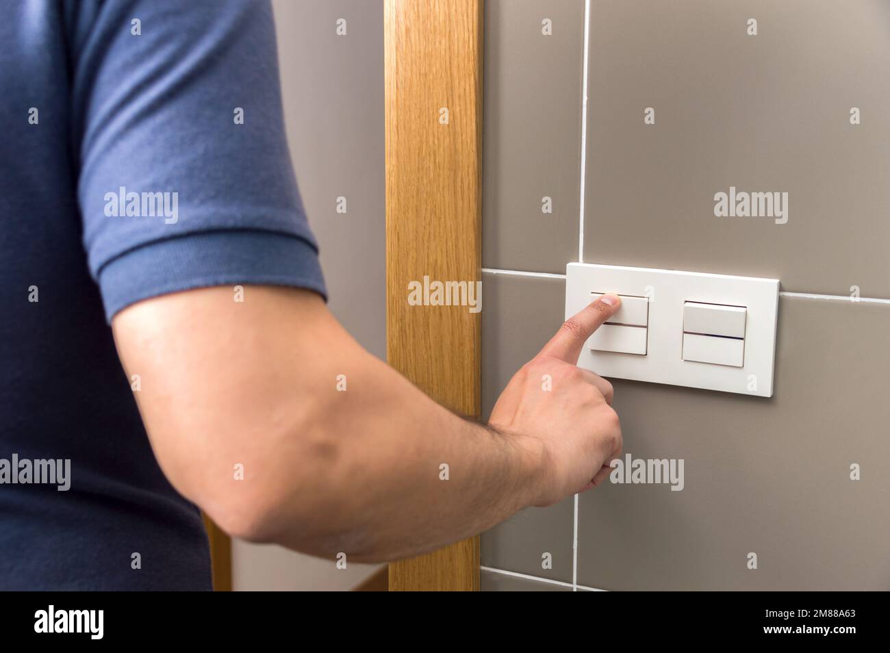 Rear view of a man turning off the bathroom light, saving concept Stock Photo