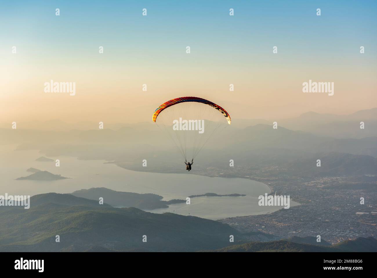 Paragliding from Babadag Mountain at Sunset overlooking Oludeniz near Fethiye in Turkey Stock Photo