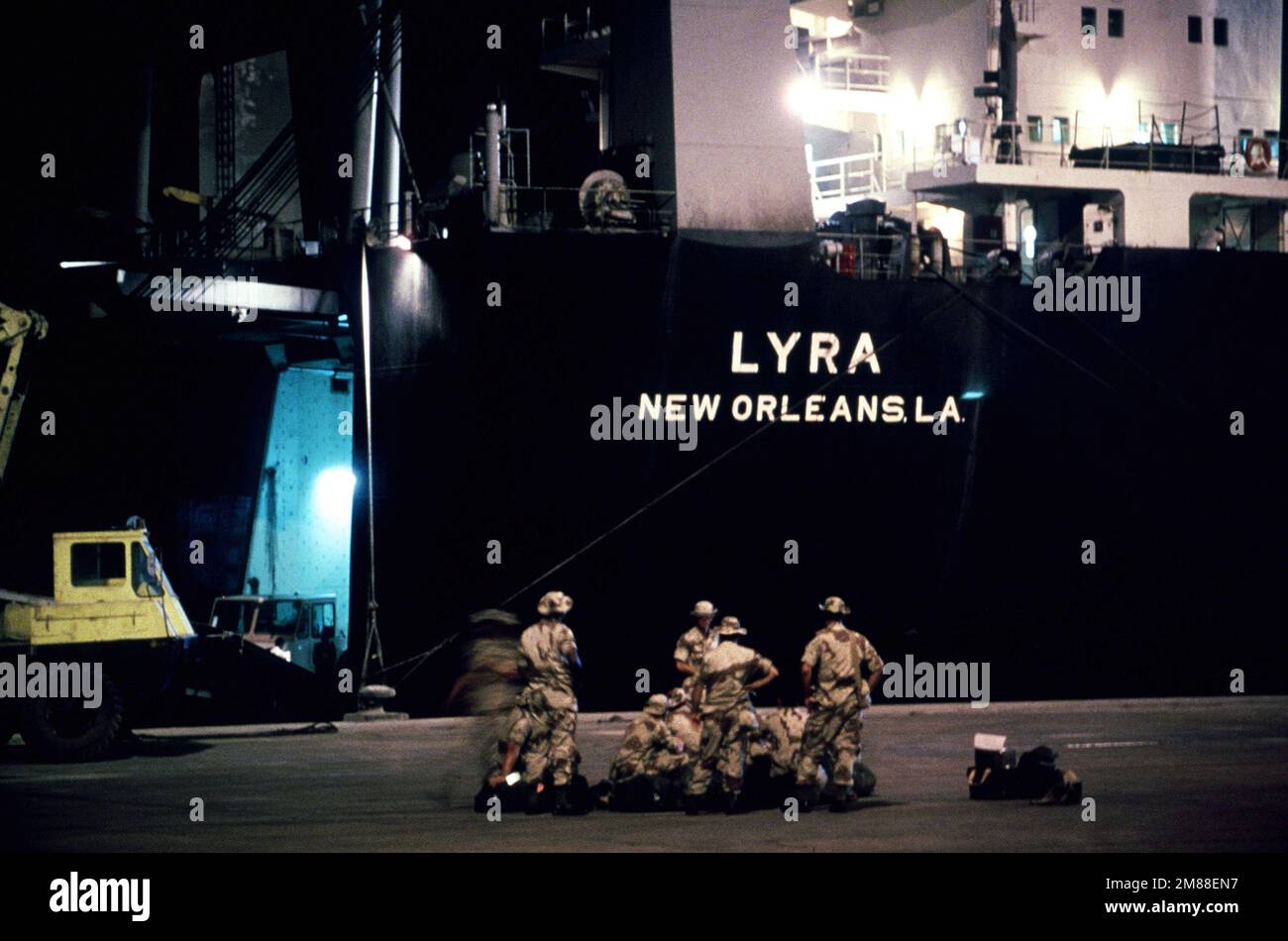 Members of the US military take a break on the dock beside the cargo ...