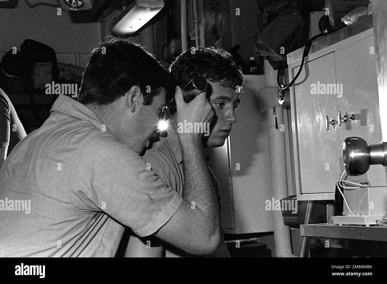 Hospital Corpsman 3rd Class Michael Cornes checks a patient's ear