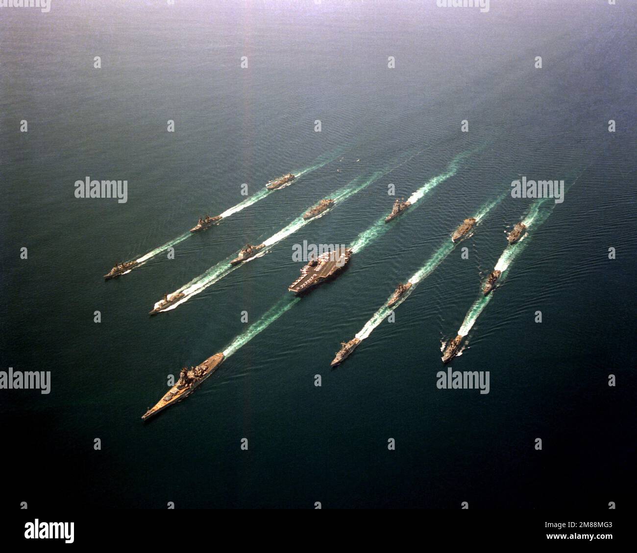 An aerial view of Battle Group Echo in formation. The ships are, from the left, top to bottom, row 1: USNS HASSAYAMPA (T-AO-145), USS LEFTWICH (DD-984), USS HOEL (DDG-13); row 2: USS KANSAS CITY (AOR-3), USS BUNKER HILL (CG-52), USS ROBERT E. PEARY (FF-1073); row 3: USS LONG BEACH (CGN-9), USS RANGER (CV-61), USS MISSOURI (BB-63); row 4: USS WICHITA (AOR-1), USS GRIDLEY (CG-21), USS CURTS (FFG-38); row 5: USS SHASTA (AE-33), USS JOHN YOUNG (DD-973) and USS BUCHANAN (DDG-14). Country: Northern Arabian Sea Stock Photo