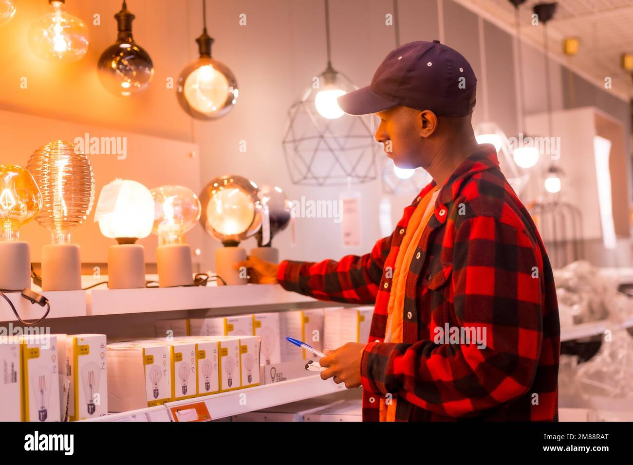 Black ethnic man shopping in a supermarket for lamps Stock Photo Alamy