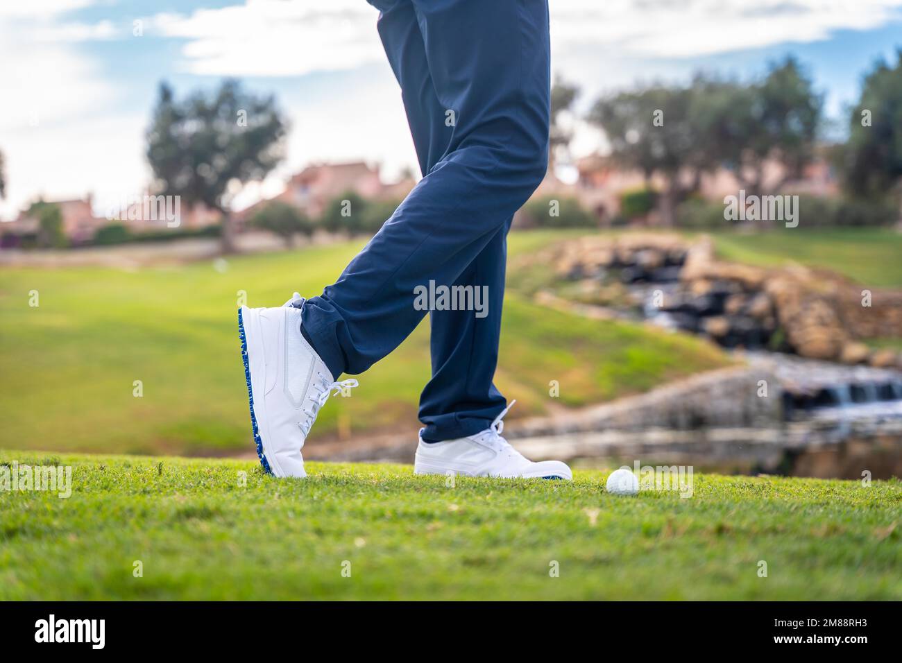 Playing golf at a lakeside golf club, hitting the ball with the iron or pitching Stock Photo