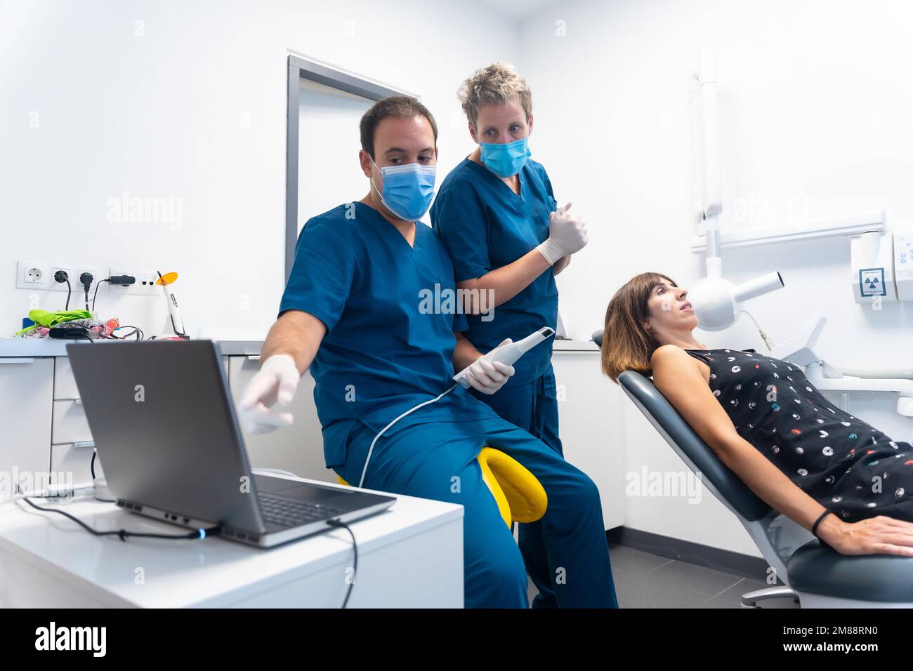 Dental clinic, dentist preparing the new scanner to make the 3d denture, explaining how it works Stock Photo