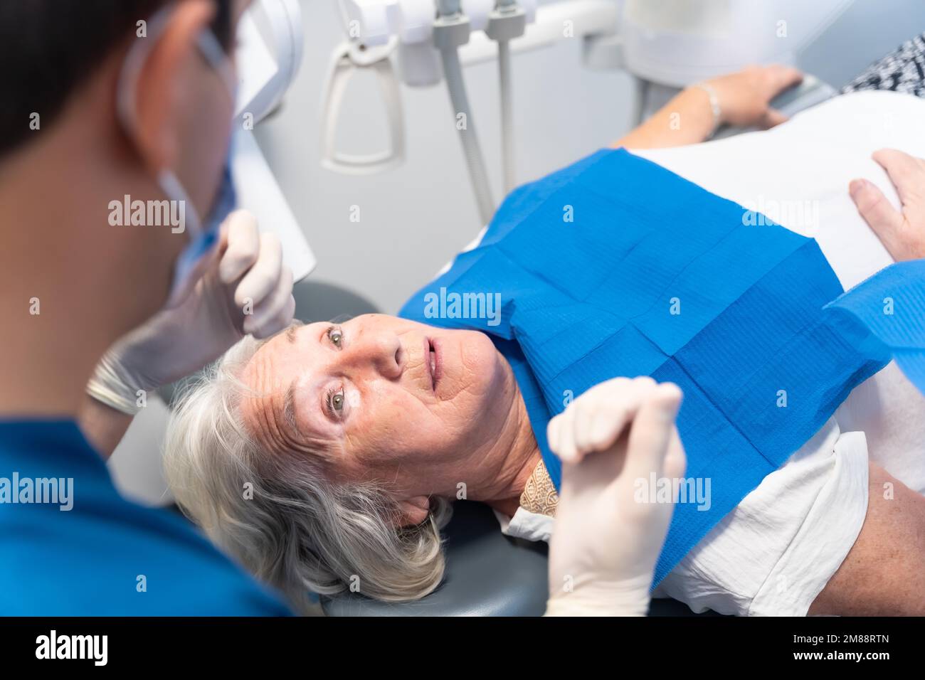 Dental clinic, doctor explaining to an elderly woman the problem she has with her teeth Stock Photo