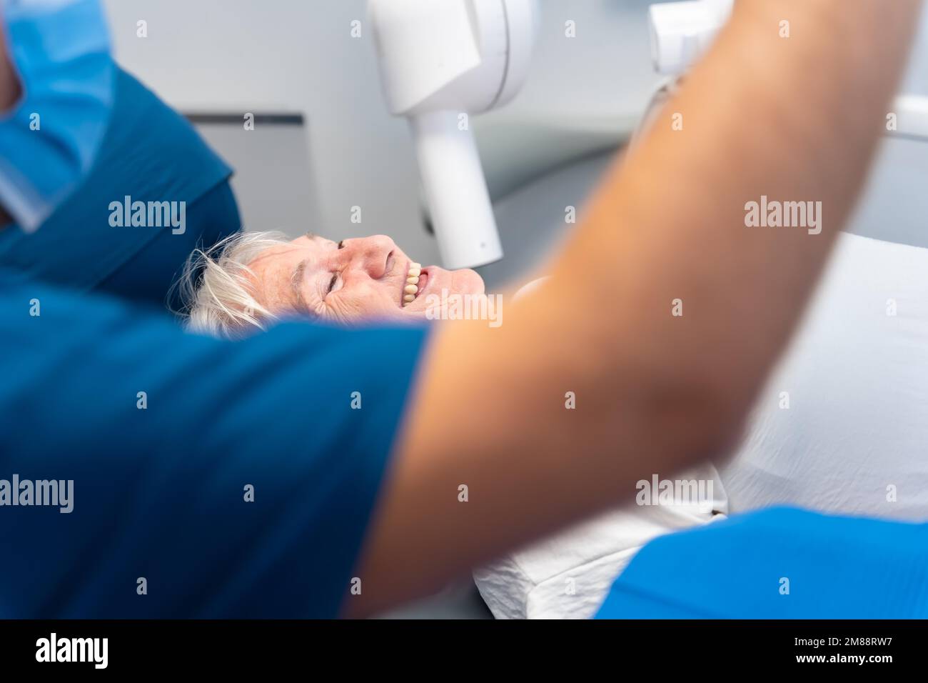 Dental clinic, elderly woman sitting smiling at the dentist waiting for denture check-up Stock Photo