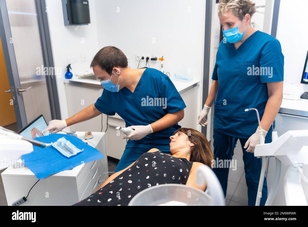 Dental clinic, dentist and assistant performing a 3d scan of the lying patient Stock Photo