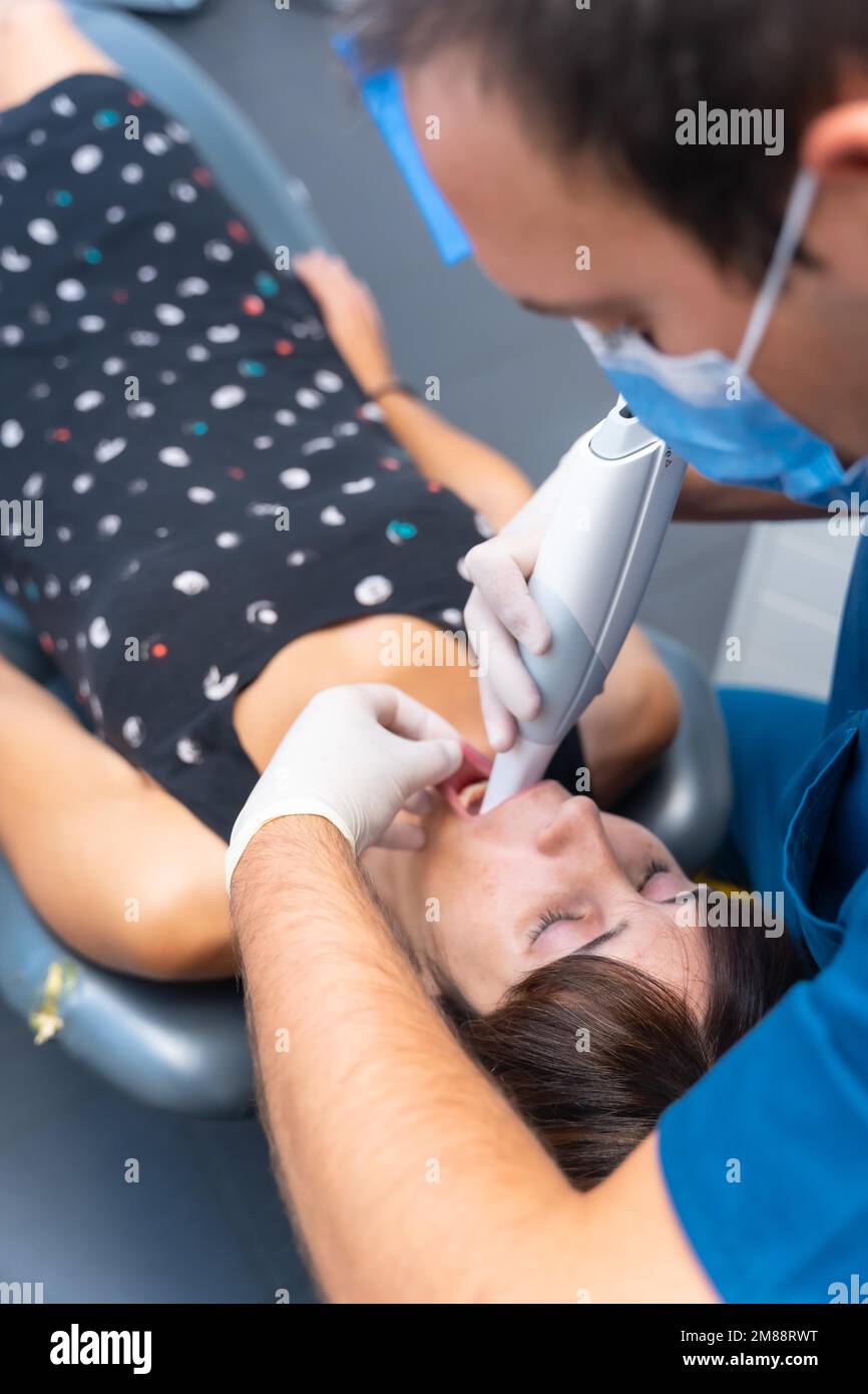 Dental clinic, dentist performing a 3d scan to the lying patient Stock Photo