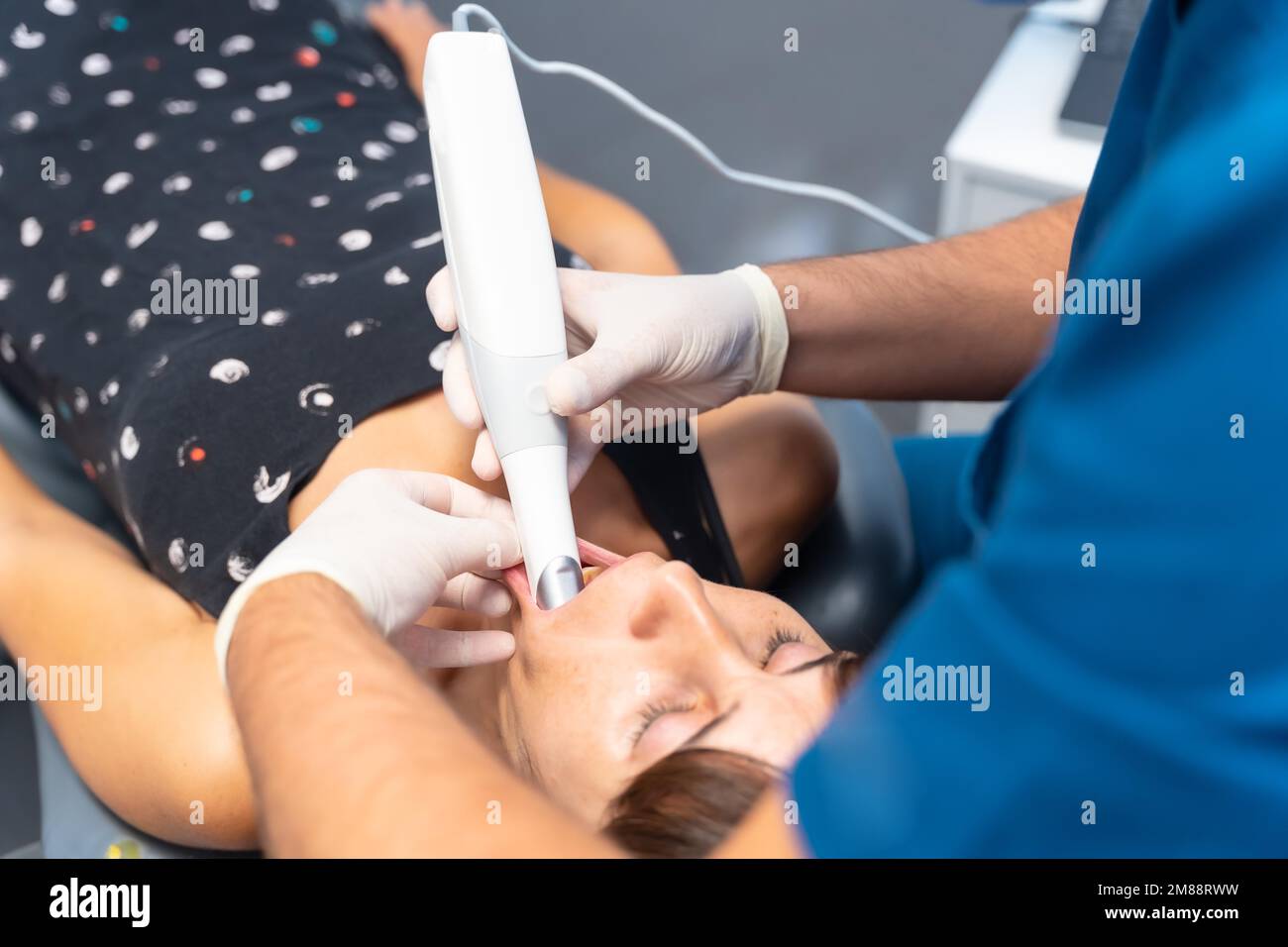 Dental clinic, dentist performing a 3d scan to the lying patient Stock Photo