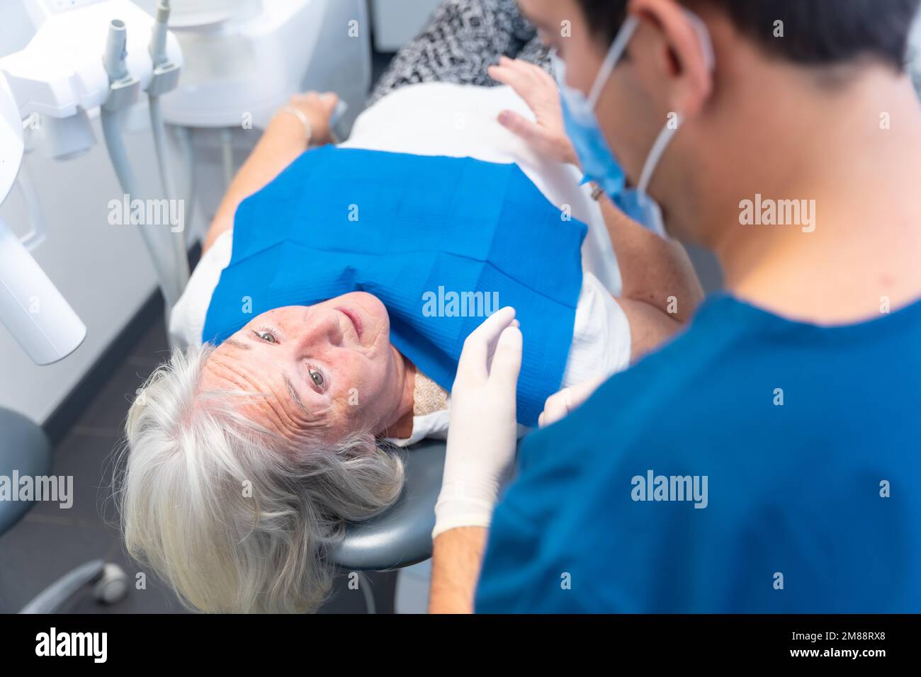 Dental clinic, doctor explaining to an elderly woman the problem she has with her teeth Stock Photo