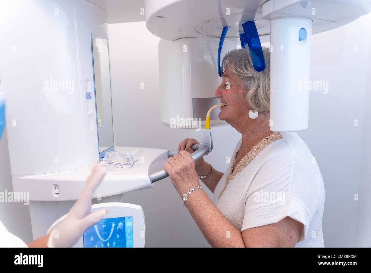 Dental clinic, elderly woman in the xray room, performing an xray