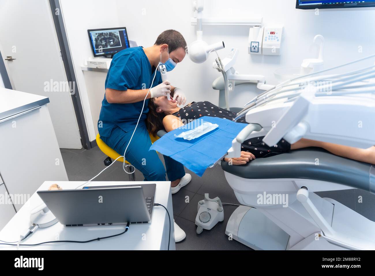 Dental clinic, dentist performing a 3d scan to the patient lying in a modern operating room Stock Photo