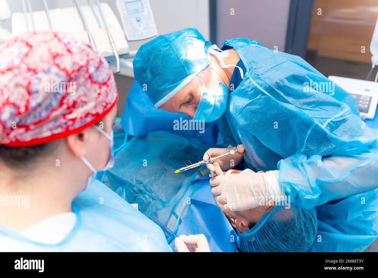 Dental clinic, dentist doctor applying anesthesia injection to patient