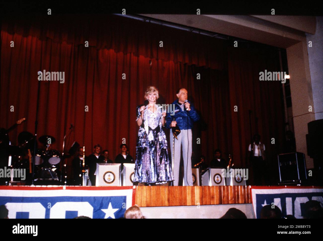 Entertainers Bob Hope and Connie Stevens, backed by the Pacific Fleet Band, perform at a United Service Organizations (USO) show in the base theater. Base: Naval Station, Rota Country: Spain (ESP) Stock Photo