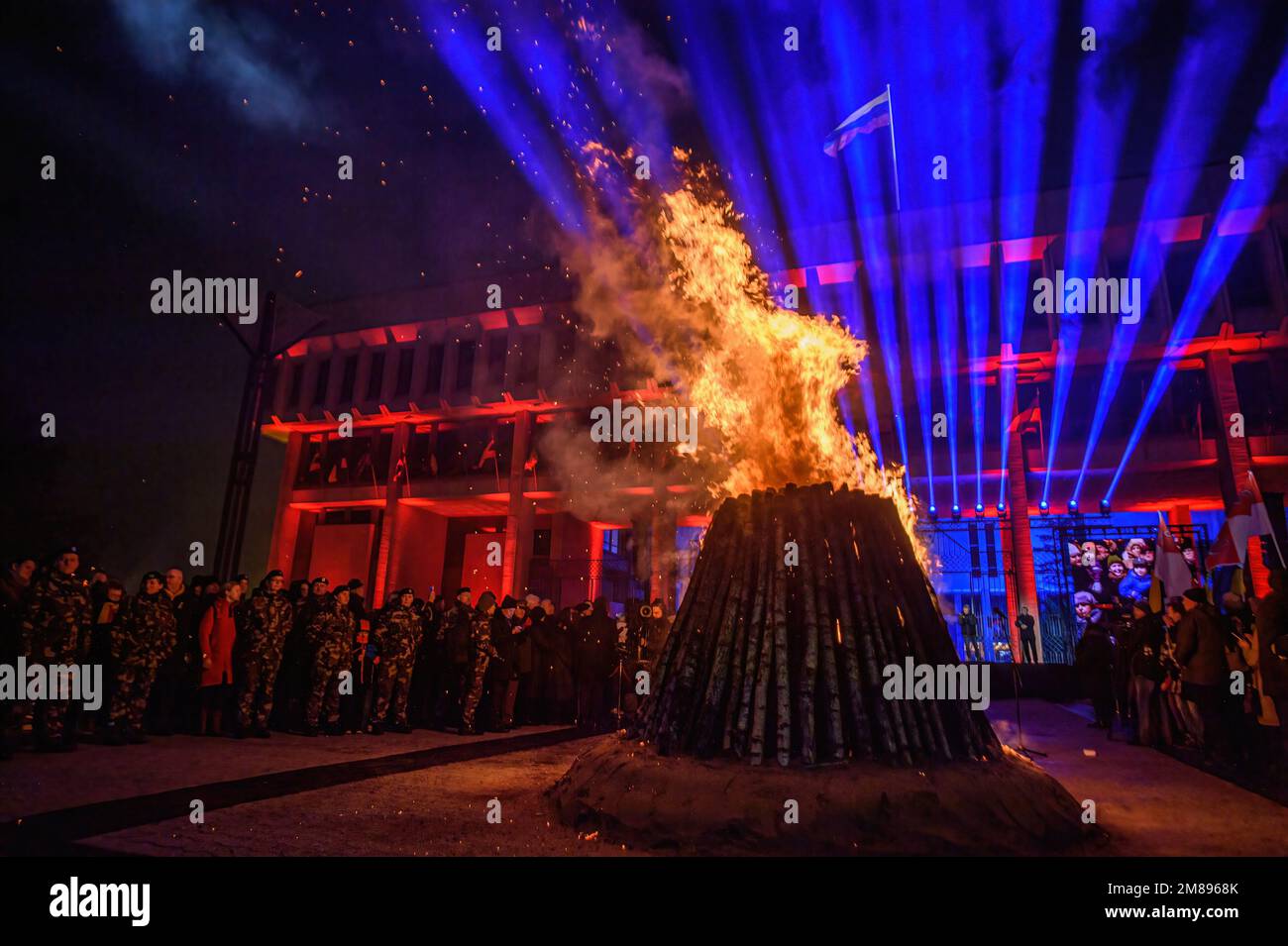 People gather around the bonfire at the Independence Square near the Lithuanian Parliament building on the eve of the 32nd anniversary of the Day of the Defenders of Freedom 'Battle for the Freedom of Nations' in Vilnius The ceremonial lighting of bonfires took place near the Vilnius TV tower and on the Independence Square on the eve of the day of remembrance for the victims of the January 1991 events, when 14 people died and many were injured during the assault by Soviet troops on the television center in Vilnius. Stock Photo