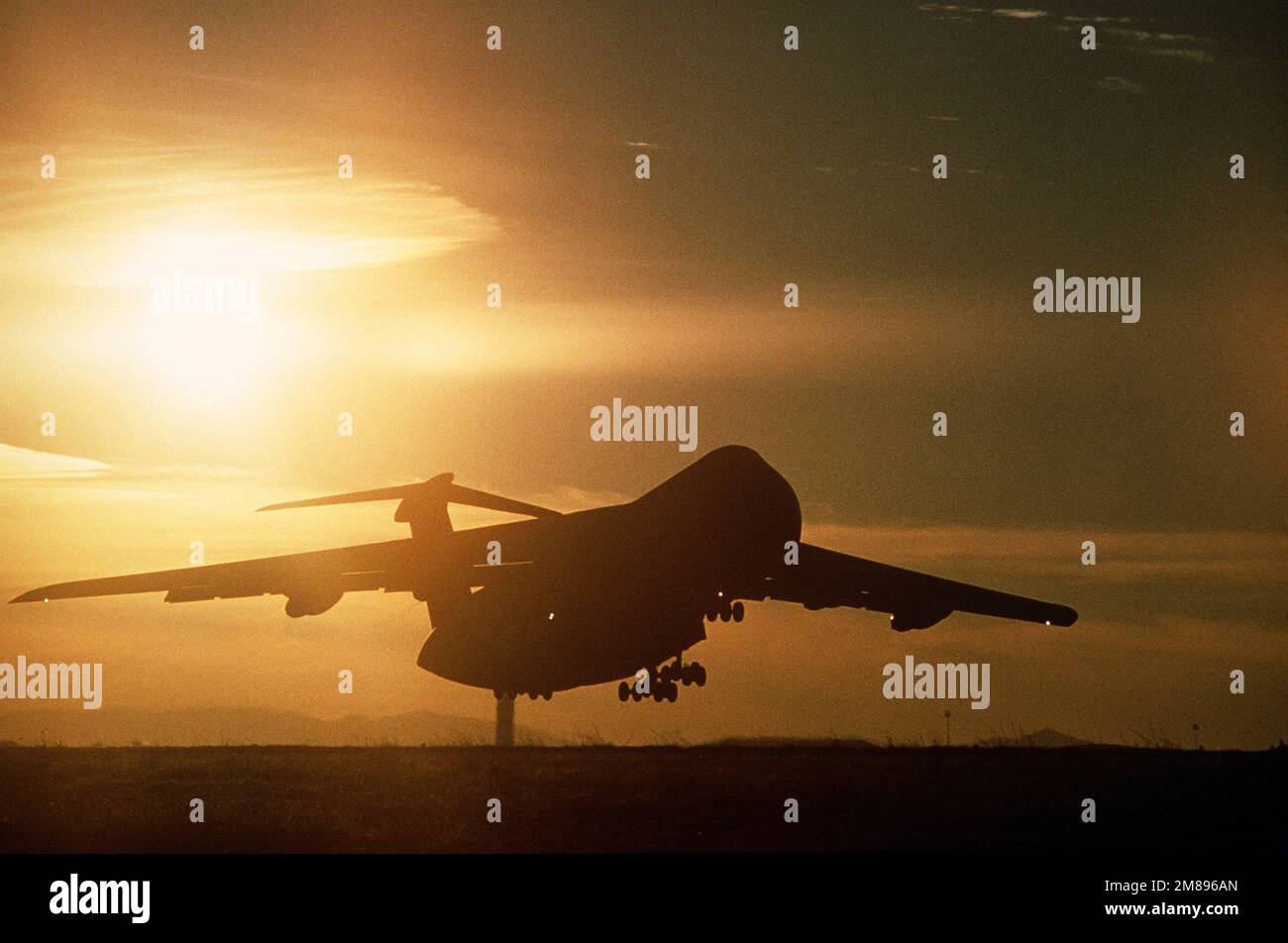 A 60th Military Airlift Squadron C-5 Galaxy aircraft is silhouetted by the sun as it takes off for the Philippines. The Galaxy is transporting medical supplies, gathered by Americares Foundation, to Philippine hospitals. Base: Travis Air Force Base State: California (CA) Country: United States Of America (USA) Stock Photo