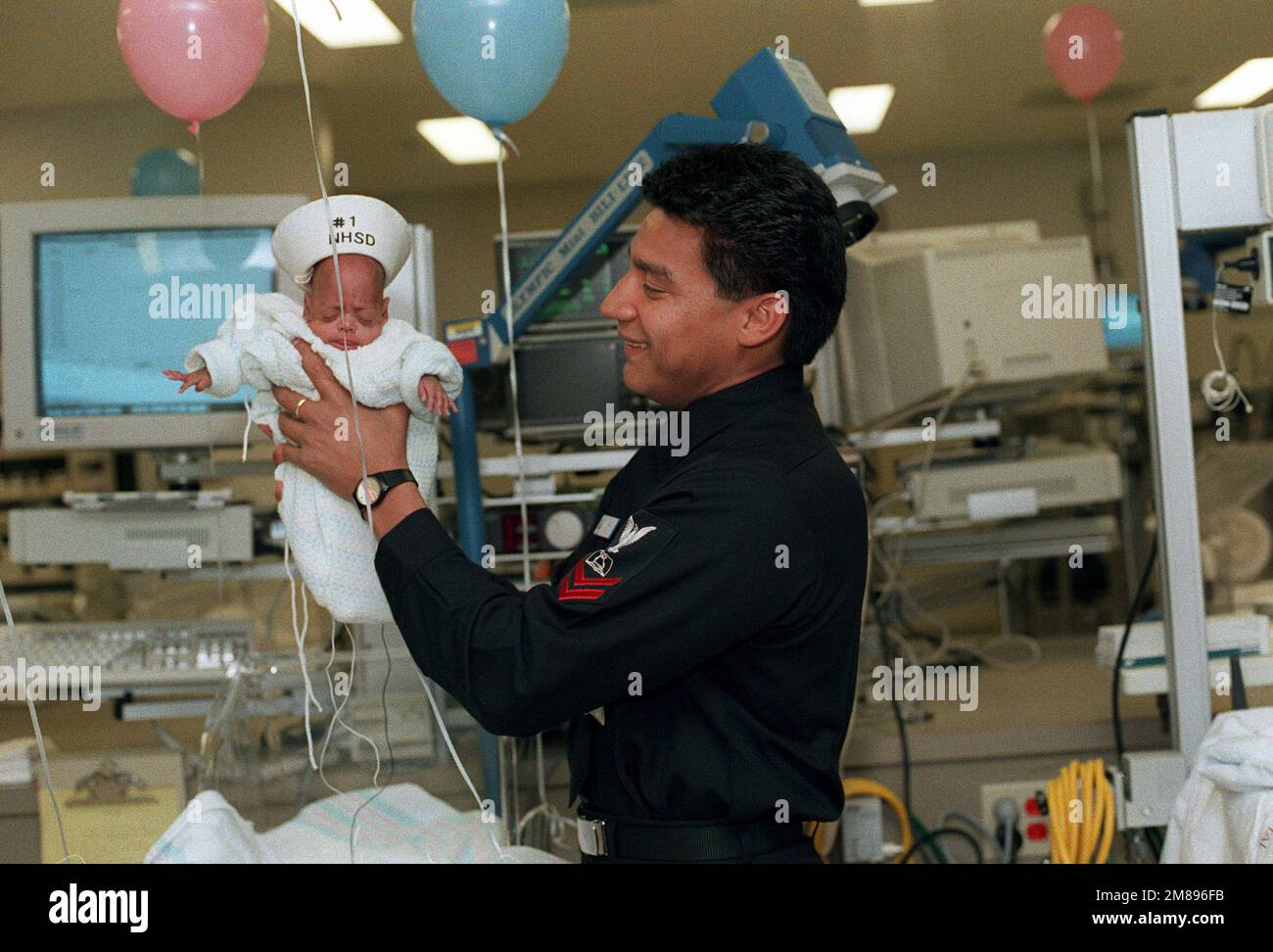 Mess Management SPECIALIST 2nd Class Huezo holds his son, Antonio, in the intensive care unit of the new Balboa Naval Hospital. The infant is the first patient to be transferred from the old Navy hospital to the new facility, located in Murphy Canyon. Base: San Diego State: California (CA) Country: United States Of America (USA) Stock Photo