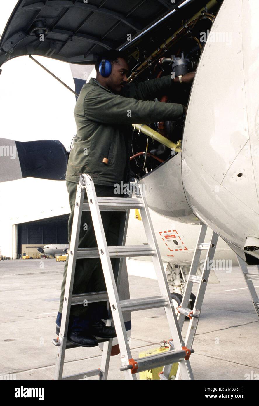 Aviation Machinist's Mate AIRMAN Mark A. Marinnie, a member of the Operations Maintenace Department, works on one of the port side engines of a P-3 Orion aircraft. Base: Naval Air Station, Sigonella State: Sicily Country: Italy (ITA) Stock Photo