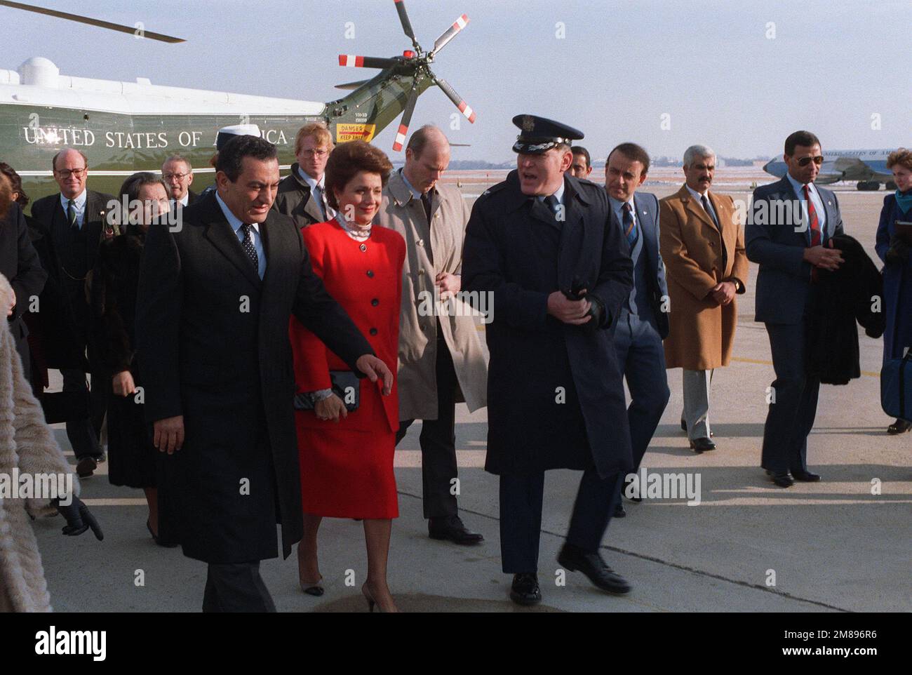 COL John Bacs, Vice Commander, Air Force District of Washington, accompanies Egyptian President Mohammed Hosni Mubarak and his wife as they walk toward the president's aircraft. The Mubaraks and their party have come to the base to begin their journey back to Egypt following a state visit. A Marine Helicopter Squadron 1 (HMX-1) VH-3D Sea King helicopter is in the background. Base: Andrews Air Force Base State: Maryland (MD) Country: United States Of America (USA) Stock Photo