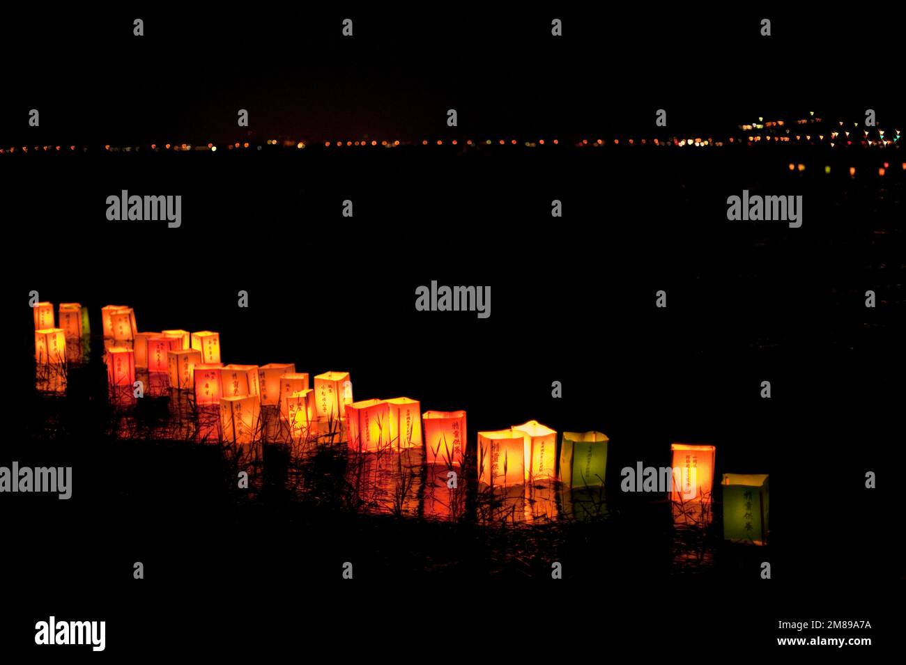 Lanterns, marked with a loved one’s name, float in Lake Suwa during the Obon festival of the dead, Okaya, Japan. Stock Photo